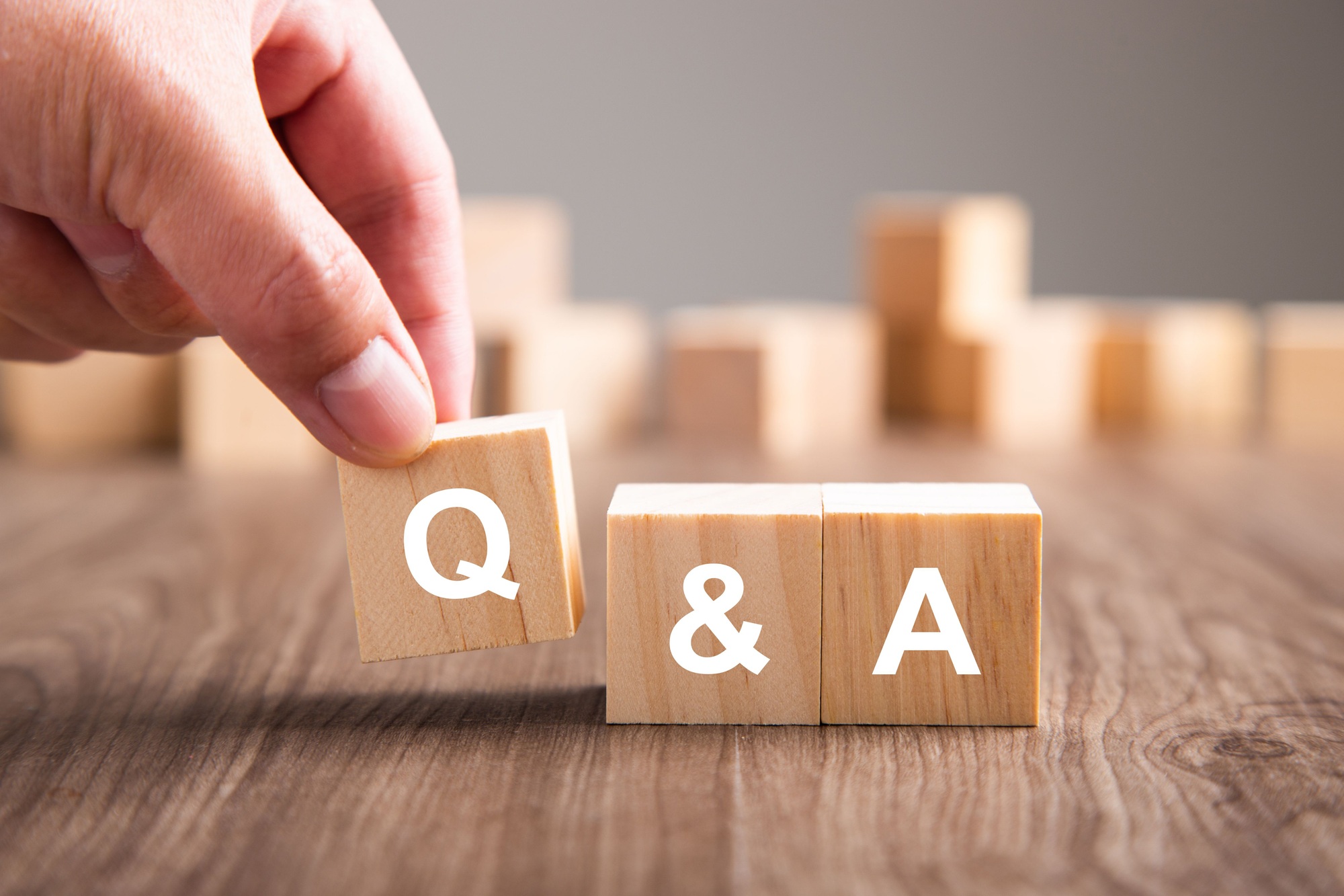 Selective focus shot of three wooden cubes with the letters Q and A - questions and answers concept