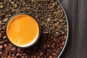Composition of green tea, coffee beans and coffee in a cup on a dark background top view close-up.