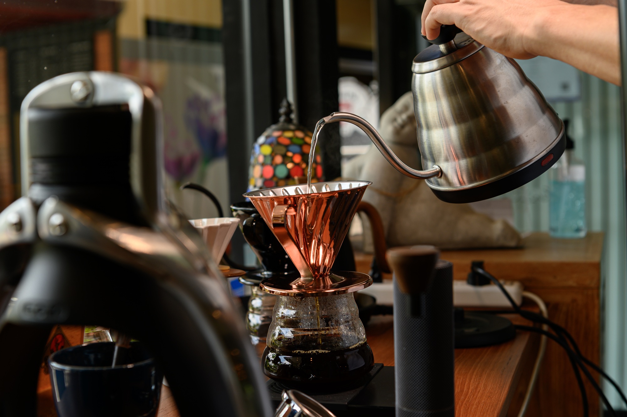 The barista is making coffee in a drip method for customers.